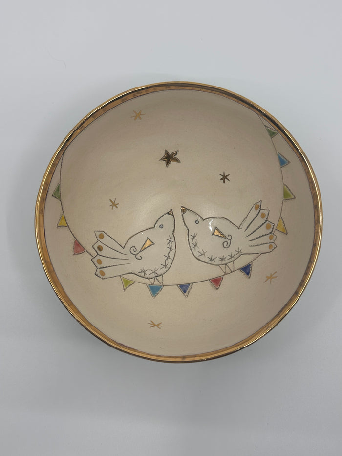 Ceramic bowl with decorative birds and geometric patterns on a plain background