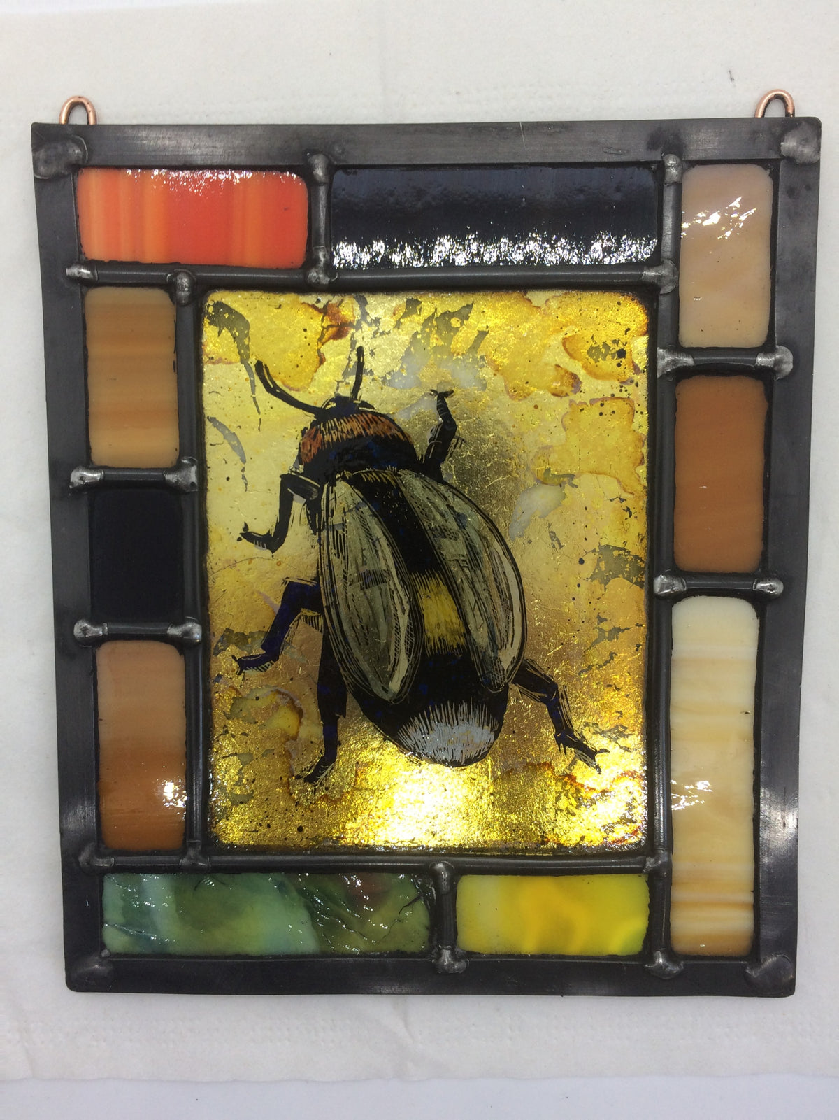 Bee in border of brown, gilded, stained glass by Bryan Smith