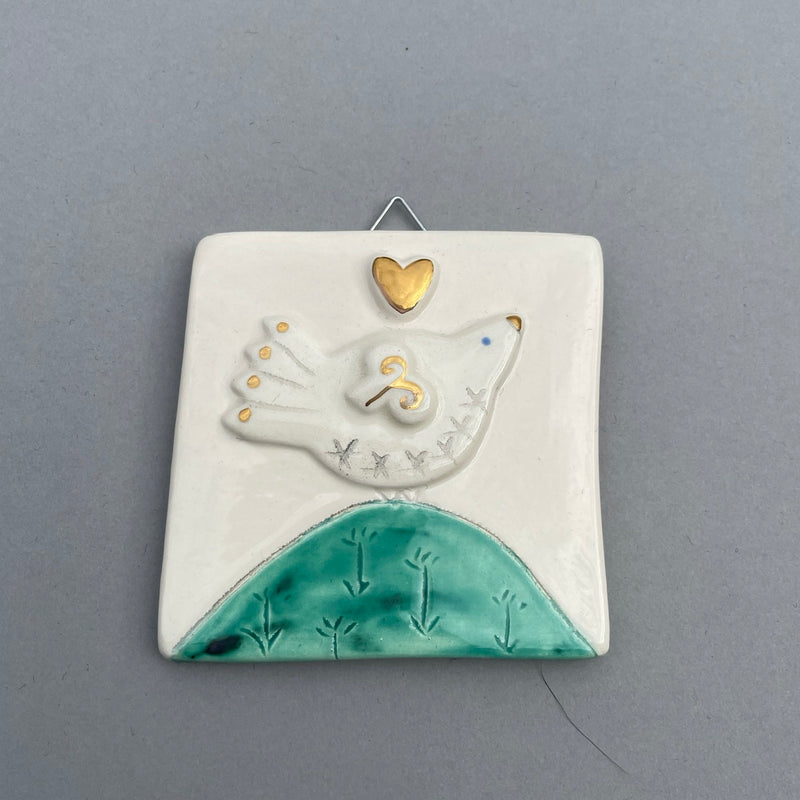 Bird on mound with gold heart hanging tile by Sophie Smith
